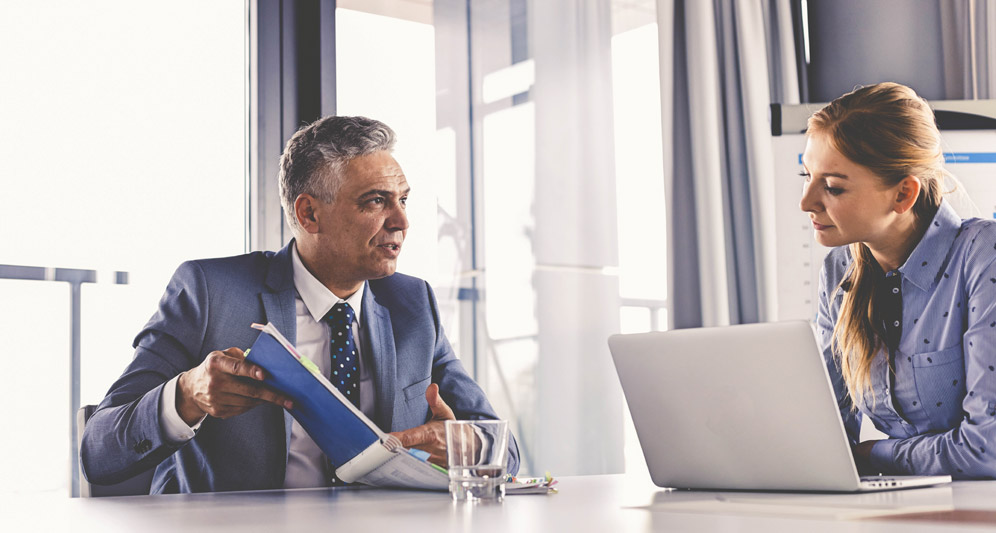 powerdms-assets-photos-020-men-talking-files-women-desk