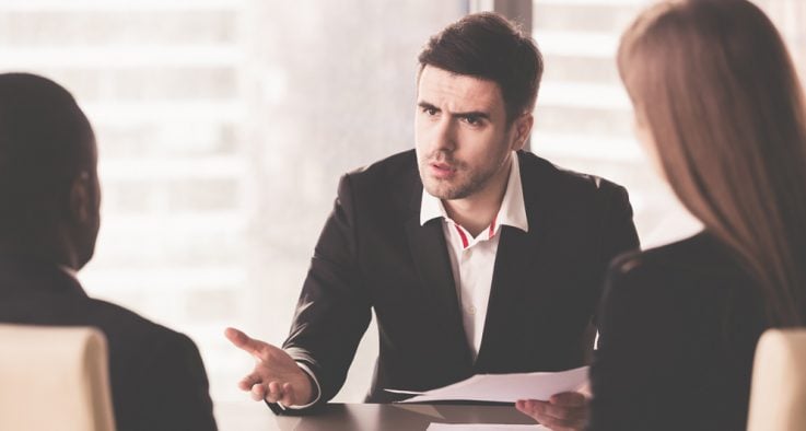 man speaking in board meeting