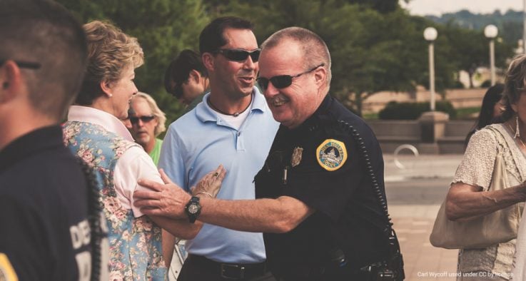 Police officer greets members of the community at an outdoor event.