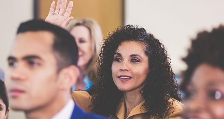 Woman raising hand at a conference