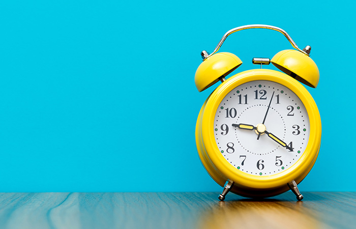 Yellow alarm clock with blue background
