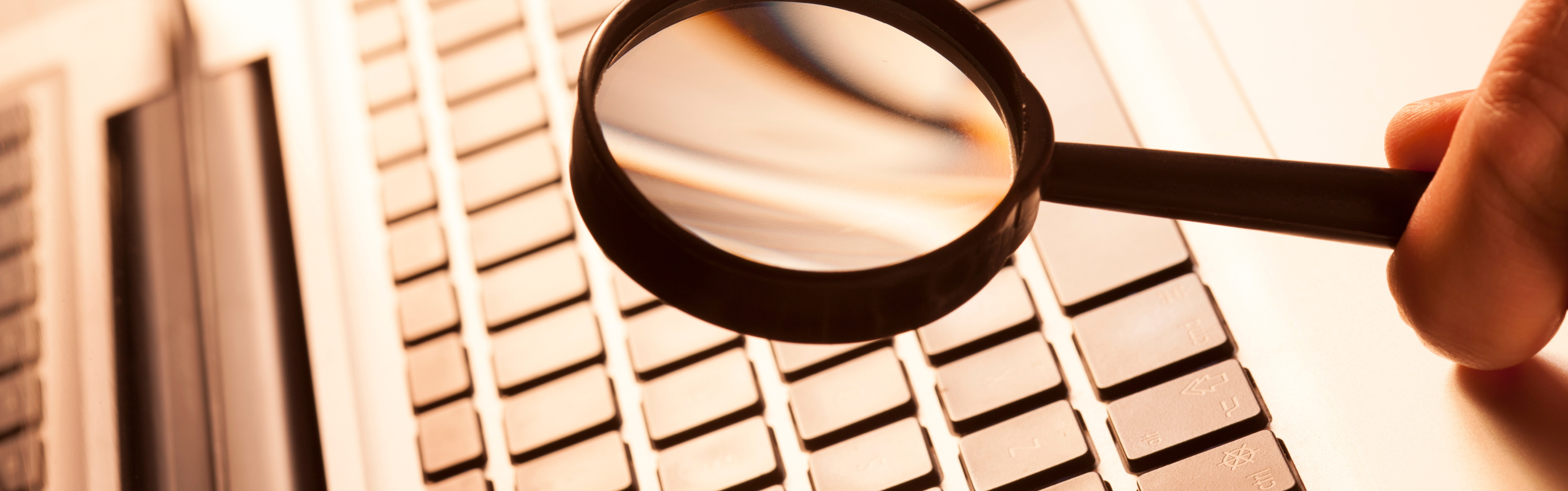 magnifying-glass-looking-at-laptop-keyboard
