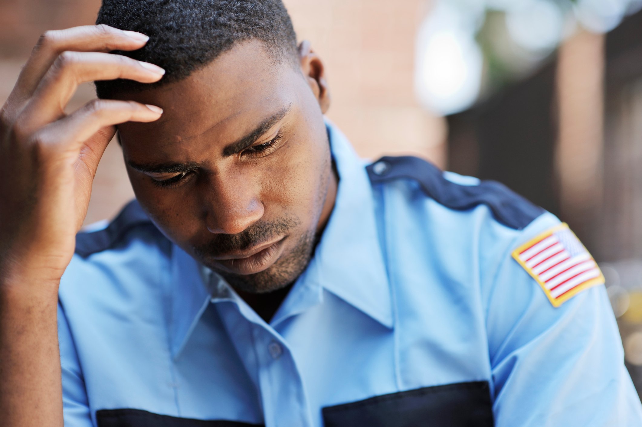 pensive police officer with hand on head