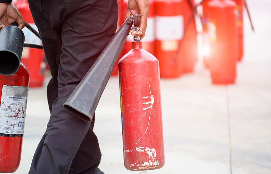 fireman carrying fire extinguishers