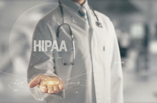 Doctor holding the word HIPAA in his hand