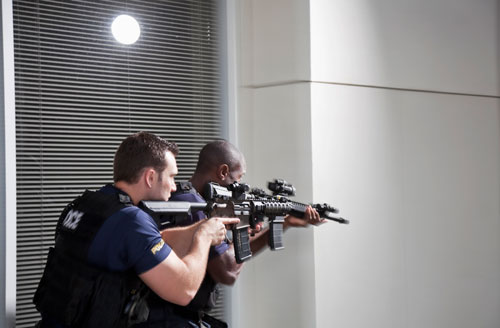 two police officers entering building with rifles