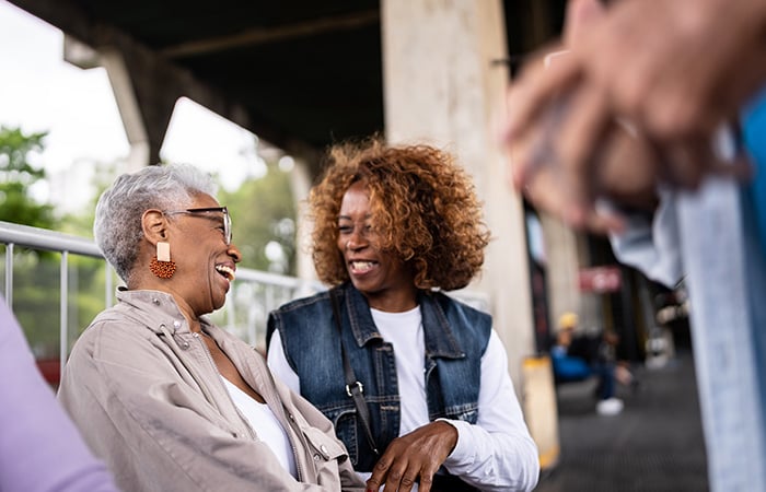 two women talking and laughing in public